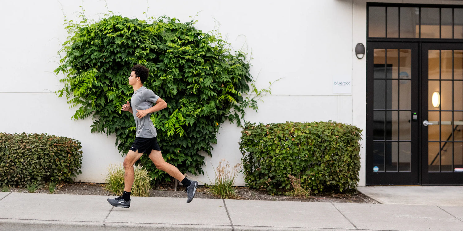 Man running up slight incline on sidewalk wearing Superfeet active support insoles.